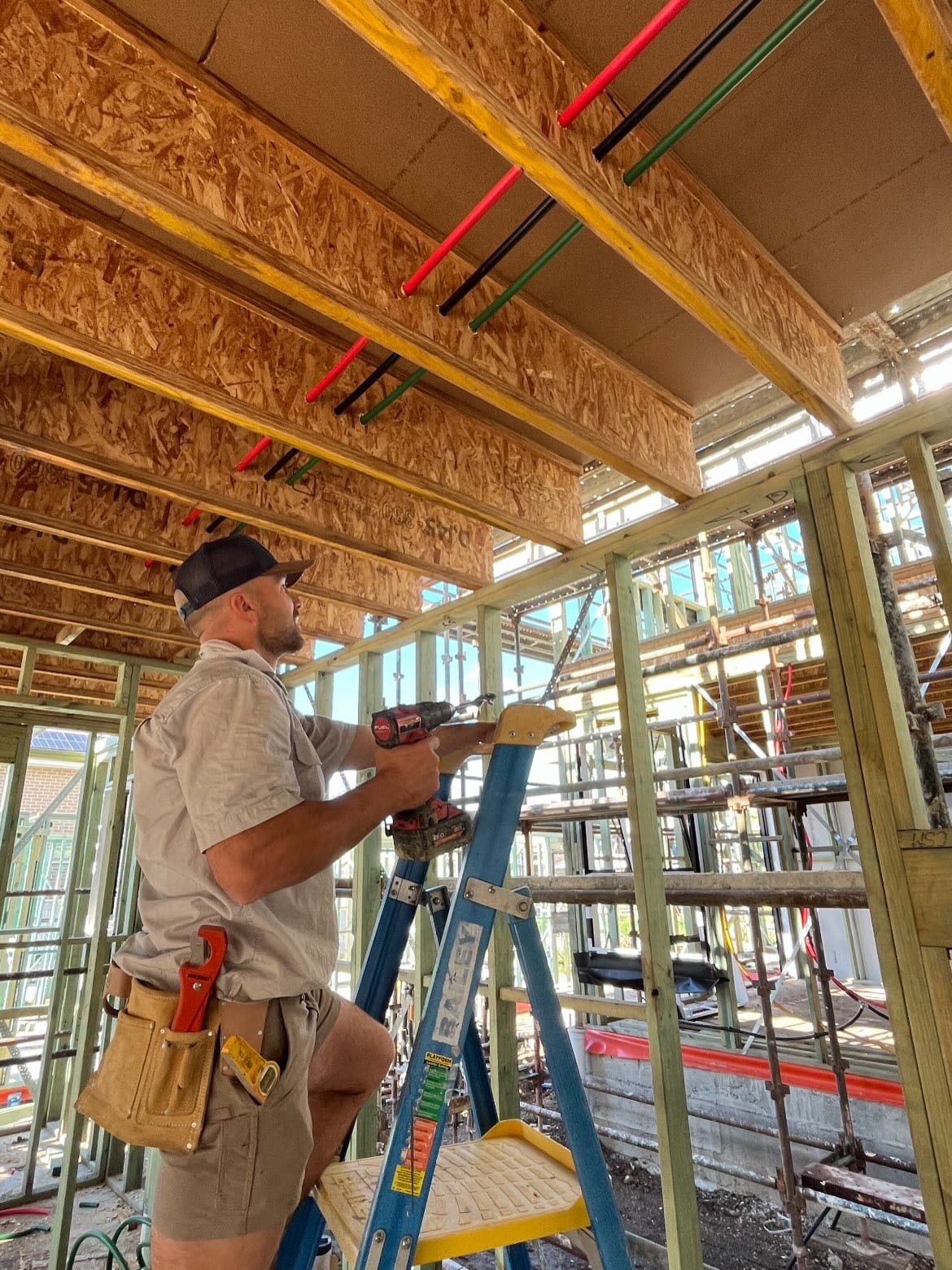 Kyle Simone installing plumbing services inside a timber-framed new build